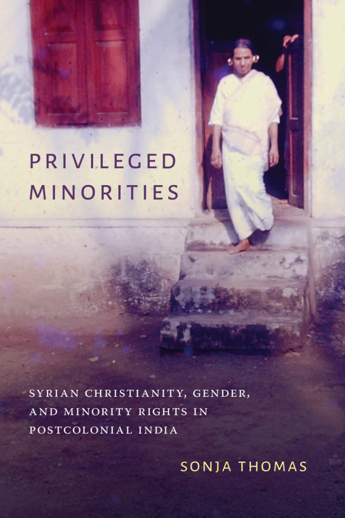 Book cover image: In the background, a person clad in traditional white Syrian Christian clothing, with gold rings on their ears, stands on the steps before the door of a house, a closed window to their left. In the foreground, there is the title, "Privileged Minorities," the subtitle, "Syrian Christianity, gender and minority rights in postcolonial India," and the author's name, "Sonja Thomas."