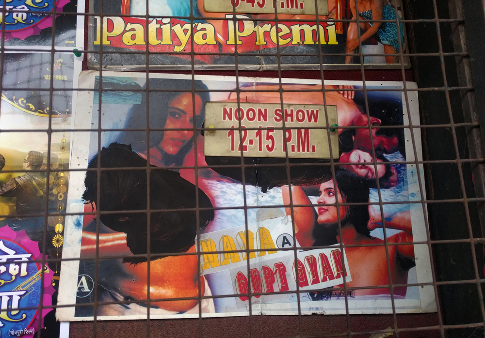 A photograph of a movie poster. The title, 'Naya Gupt Gyan' is displayed along with images of two semi-clothed women, as well as a man and a woman embracing. For one of the women, the upper body is blacked out.